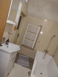 a bathroom with a sink and a toilet and a window at Evelin sobe in Bačka Topola