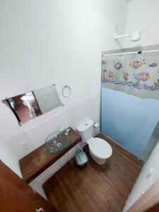 Suites por do Sol في بوزيوس: حمام صغير مع مرحاض ومغسلة