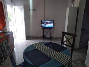 a living room with a tv and a table with a bed at Depto Guemes in San Luis