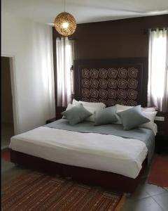 ein Schlafzimmer mit einem großen Bett mit weißer Bettwäsche und Kissen in der Unterkunft Villa Toufitri in Agadir