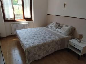 una camera con un letto e un comodino e due finestre di La Casa di Anna nel Parco della Majella Abruzzo Rapino CH a Rapino