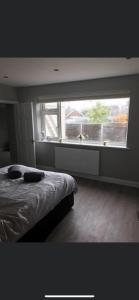 a bedroom with a bed and a large window at Inviting 2-Bed Bungalow in Heacham with spa bath in Heacham