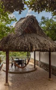 a straw hut with a table and a chair under it at Casa Mirador del Cielo in Taganga