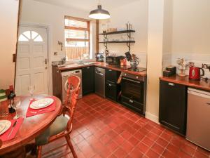 a kitchen with a table and a dining room at Mill Cottage in Leek