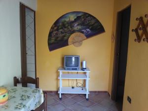 ランペドゥーザにあるIl Sole Di Lampedusaの小型テレビ、テーブル(トビクスター付)が備わる客室です。