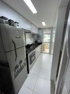 uma cozinha com electrodomésticos em aço inoxidável e pisos em azulejo branco em Paraíso à sua Porta Ap Luxuoso Prédio Frontal Mar no Rio de Janeiro