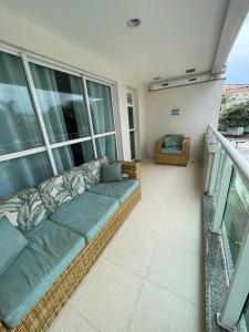 un sofá en el balcón de una casa en Paraíso à sua Porta Ap Luxuoso Prédio Frontal Mar, en Río de Janeiro