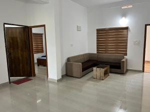 a living room with a couch and a table at Wayanad Biriyomz Residency, Kalpatta, Low Cost Rooms and Deluxe Apartment in Kalpetta