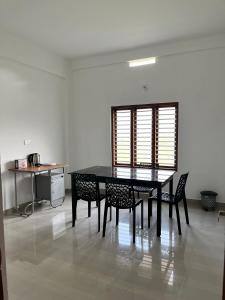 a dining room table and chairs in a room at Wayanad Biriyomz Residency, Kalpatta, Low Cost Rooms and Deluxe Apartment in Kalpetta +38 photos