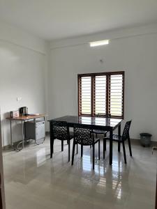 a dining room table and chairs in a room at Wayanad Biriyomz Residency, Kalpatta, Low Cost Rooms and Deluxe Apartment in Kalpetta