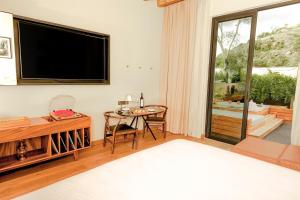 a living room with a flat screen tv and a table at Live Aqua San Miguel de Allende in San Miguel de Allende
