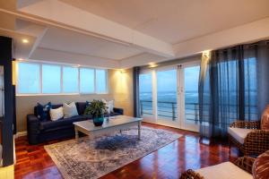 Cape Recife Lighthouse Luxury Villa في بورت اليزابيث: غرفة معيشة مع أريكة وطاولة