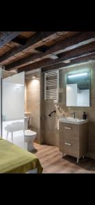 W łazience znajduje się umywalka, toaleta i lustro. w obiekcie Experiencia en Triana w Sewilli