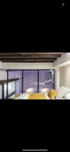 sypialnia z łóżkiem z żółtą pościelą i oknem w obiekcie Experiencia en Triana w Sewilli