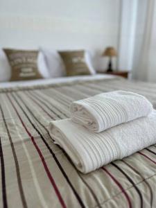 dos toallas sentadas encima de una cama en Depto Barrio La Perla en Mar del Plata