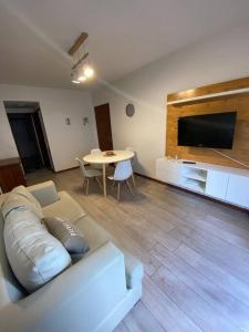 sala de estar con sofá, TV y mesa en Depto Barrio La Perla en Mar del Plata