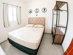 a small bedroom with a bed and a shelf at APARTAMENTO COM PISCINA E CHURRASQUEIRA in Ubatuba