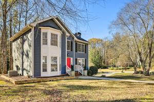 una casa azul y blanca con una puerta roja en Bright Sugar Hills Home about 5 Mi to Lake Lanier, en Sugar Hill