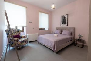 sypialnia z łóżkiem i krzesłem w obiekcie Orion Maison: Luxury 3-bedroom maisonette in the center of town w mieście Gythio