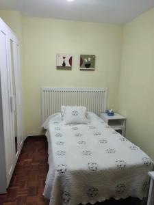 ein Schlafzimmer mit einem Bett mit einer weißen Decke in der Unterkunft Cuenca 3 in Gijón