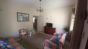 a living room with two chairs and a tv at Residência Manto Azul in Aparecida
