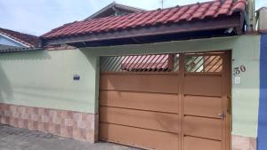 a garage with a brown door on a house at Residência Manto Azul in Aparecida