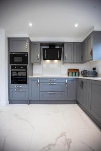 a kitchen with blue cabinets and a white tile floor at Luxury House in Clitheroe in Clitheroe