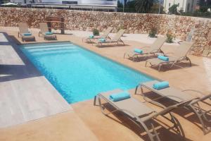 a swimming pool with lounge chairs and a swimming pool at VILLA NOKA in Cala en Blanes