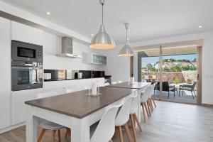a kitchen and dining room with a table and chairs at VILLA NOKA in Cala en Blanes