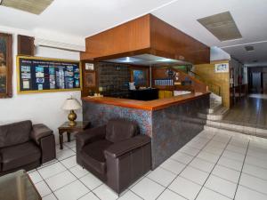 um átrio com duas cadeiras e um bar em Hotel Canada em Guadalajara