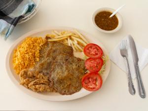 einen Teller mit Fleisch und Reis und eine Schüssel Sauce in der Unterkunft Hotel Canada in Guadalajara