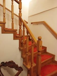 eine Holztreppe mit einem roten Teppich und einem Spiegel in der Unterkunft Grevena country House 