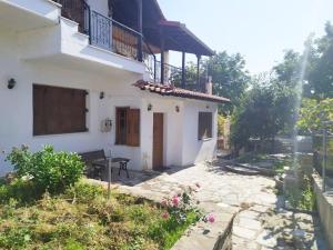 a white house with a table and a balcony at Grevena country House in Kalirákhi