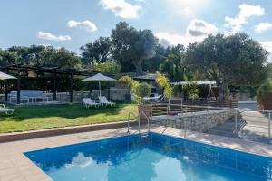 a swimming pool in a yard with a patio at Villa Vigles in Maroulás