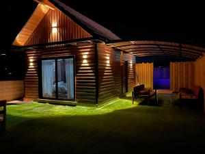 a house lit up at night with green lighting at בקתת החרמון in Mas'ada