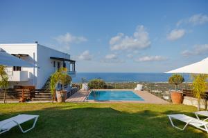 a villa with a swimming pool and the ocean at Villa Vigles in Maroulás