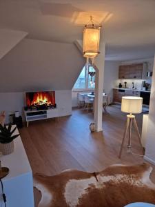 a living room with a fireplace and a dining room at Ferienwohnung für Naturliebhaber in Peenemünde