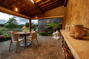 een patio met een tafel en stoelen en een groot raam bij Azores Country Nature in Lagoa