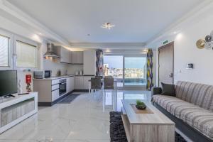 a living room and kitchen with a couch and a table at Terrace View - Stylish Two Bedroom Penthouse in Msida
