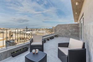 a patio with two chairs and a table on a balcony at Terrace View - Stylish Two Bedroom Penthouse in Msida