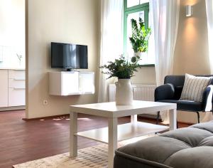 ピルナにあるHip & Minimalist - Stadt Apartments am Malerwegのリビングルーム(白いテーブル、テレビ付)