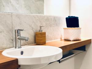 baño con lavabo blanco en una encimera de madera en Hip & Minimalist - Stadt Apartments am Malerweg en Pirna