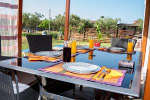 a table with plates and glasses on top of it at Konstantinos holidays house in Laganas