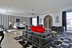 a living room with a red couch and a bed at DAR OOMI in Zarzis