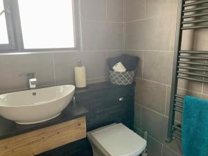 a bathroom with a sink and a toilet at Surfers Lodge - Rest Bay, Porthcawl in Porthcawl