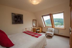 a bedroom with a bed and a desk and a window at Rothay 18 in Ambleside