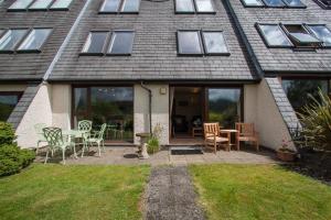 uma casa com um pátio com uma mesa e cadeiras em Rothay 18 em Ambleside