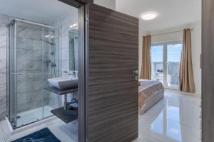 een badkamer met een douche en een wastafel bij Terrace View - Stylish Two Bedroom Penthouse in Msida