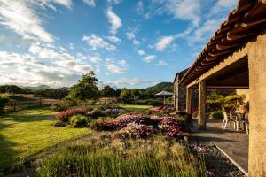 a house with a yard with flowers and a patio at Azores Country Nature in Lagoa