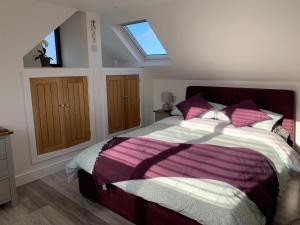 a bedroom with a large bed with a skylight at Surfers Lodge - Rest Bay, Porthcawl in Porthcawl